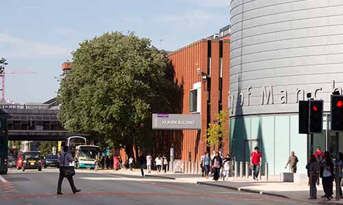 Landscape image of the front of University Place with people crossing the road.