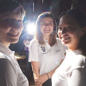 Group of students in semi darkness with a light shining between them 