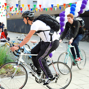 Two students riding bikes on campus 