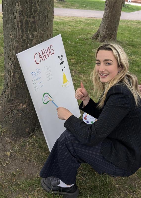 Katie writing Canvas on a Canvas board