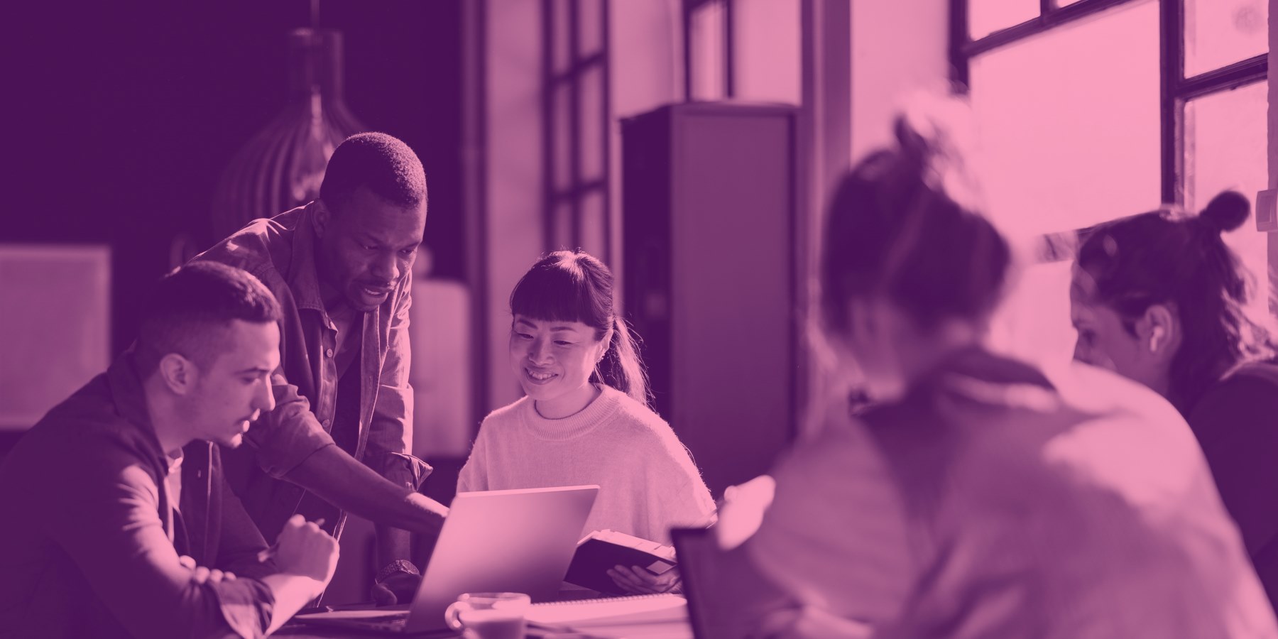 group of people working together looking at a laptop screen