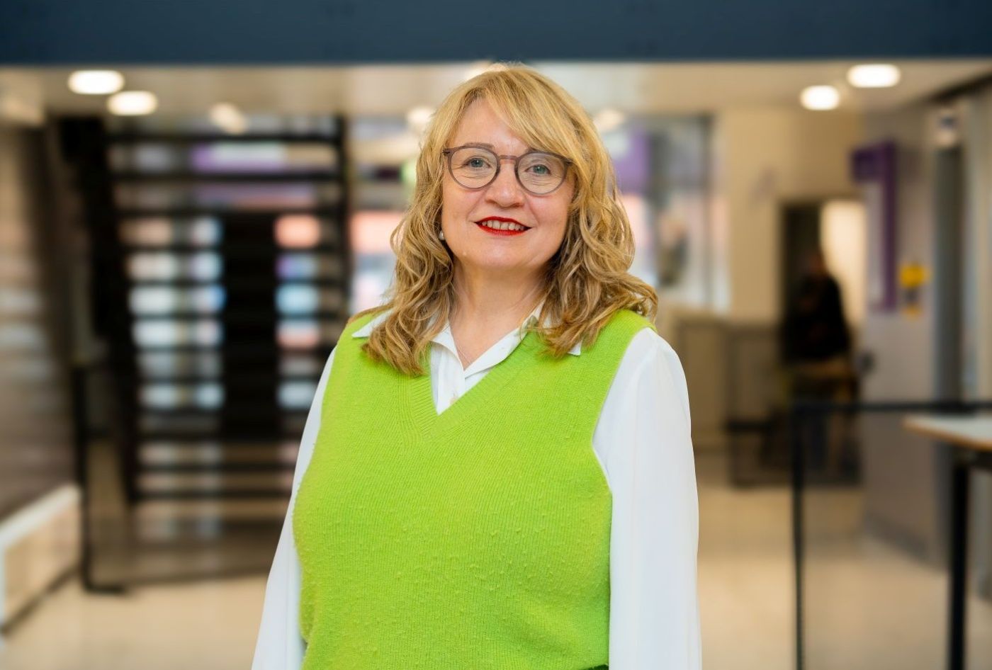 Image of a female academic wearing a green jumper over a white shirt.
