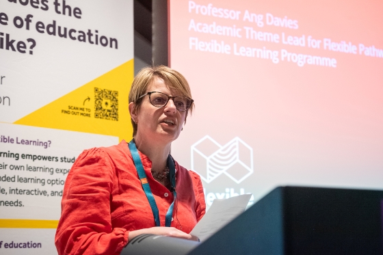 Image of Ang Davies presenting wearing a orange shirt with short blonde hair 