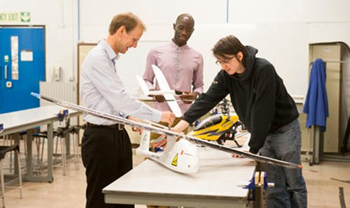 Three people making an plane model 