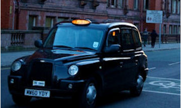 Taxi driving up a Manchester street 