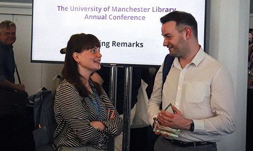 Two members of staff smiling and talking