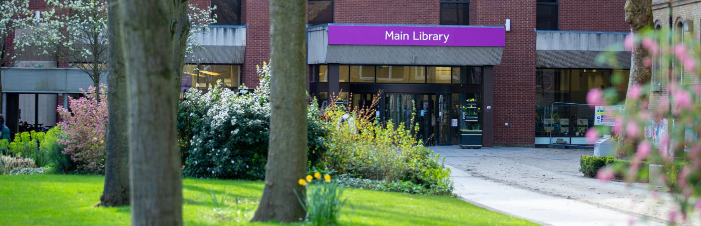 Front of Main Library with students walking along the path in Gilbert Square