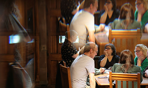 Staff engaging in a workshop sat around a wooden table