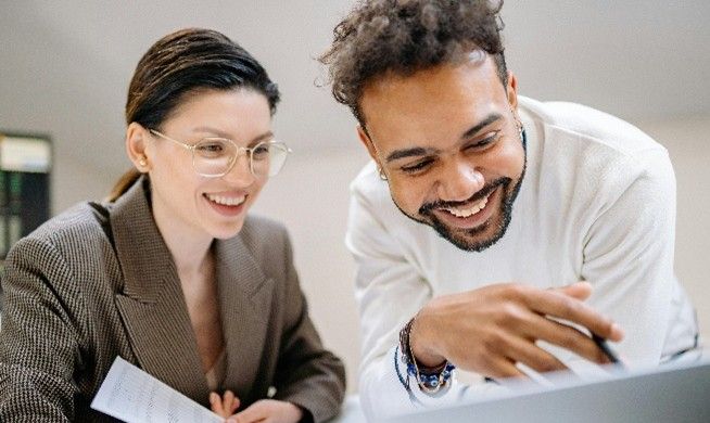 two people looking at a laptop screen
