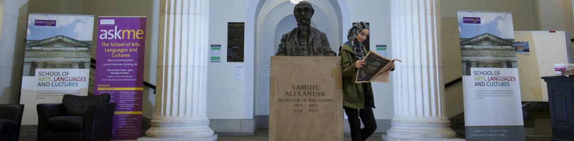 Student in foyer of the Samuel Alexander building at The University of Manchester