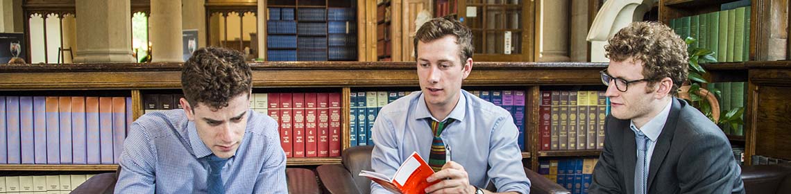 People talking over documents in old library