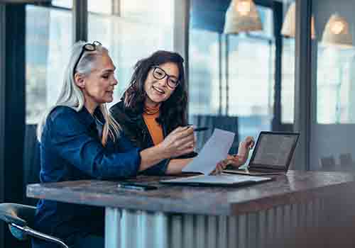 Two females working at a high-rise desk