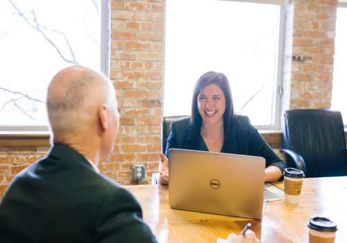 Woman smiling as she talks to a man in an office setting
