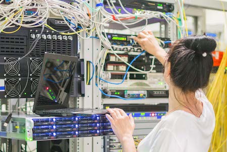 A woman configures the network by linking servers and systems together to enable her research