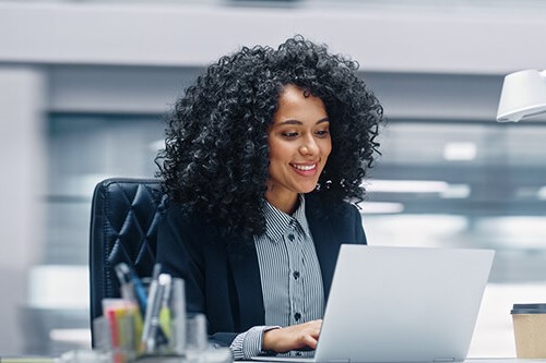 A woman sat at a desk with a laptop