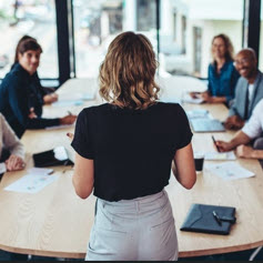 Female manager having a meeting with her team in office boardroom.