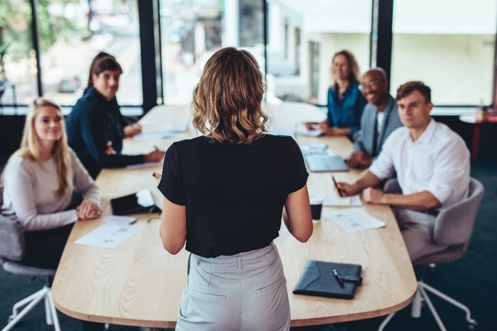 Female manager having a meeting with her team in office boardroom.