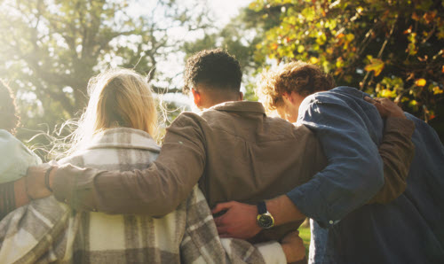 A group of people walking arm in arm