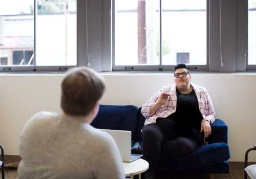 Person_sat_on_a_sofa_talking_to_someone_who_has_their_back_to_the_camera