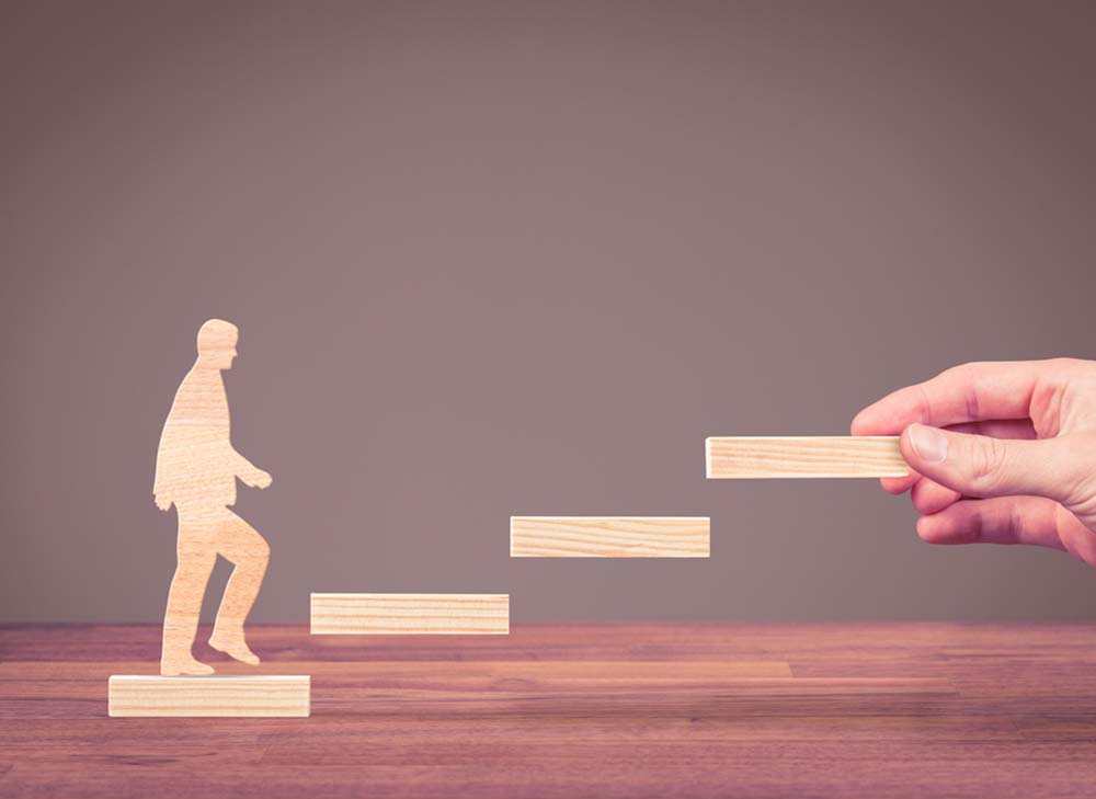 Male figure walking up floating stairs 