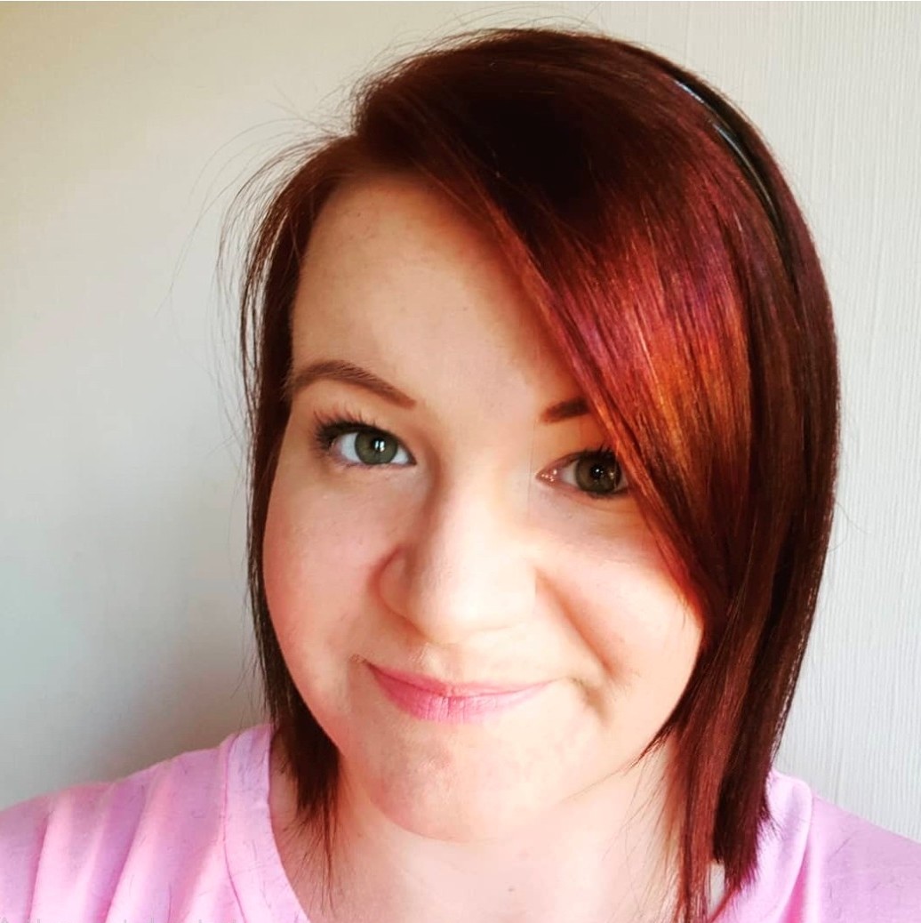 woman with short red hair smiling at the camera