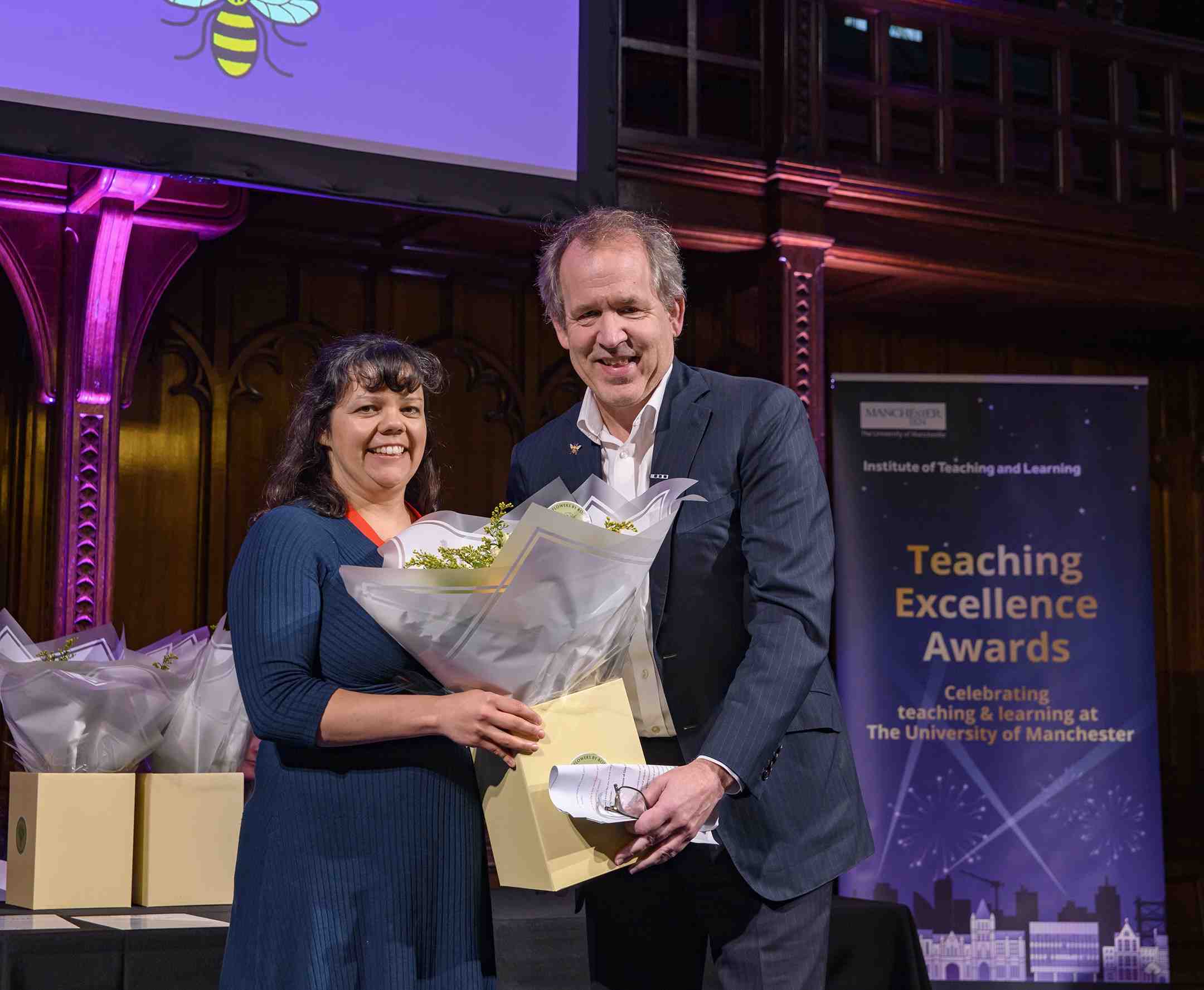 Jenni Rose receiving a bouquet of flowers from Prof Duncan Ivison at the Teaching Excellence Awards celebration event